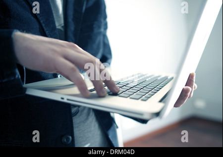 Male Businessman Working While Standing on the Laptop in Office Area. Computers Technology Photo Collection. Stock Photo