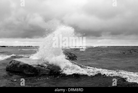White waves hit a big rock in the sea Stock Photo