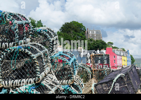 Some of the colourful houses of Tobermory framed by Crab Pots from the harbour. Stock Photo