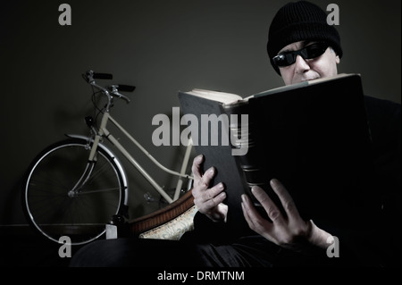 Man reading book sitting in his living room Stock Photo