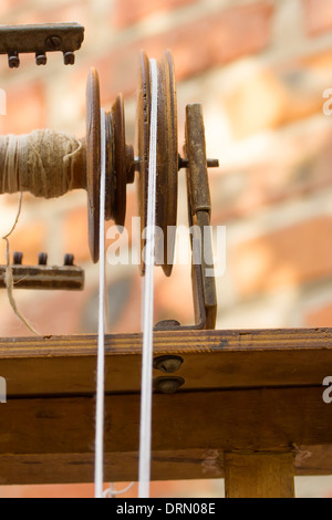 Distaff element close-up. Wool yarn passes through the pulley Stock Photo