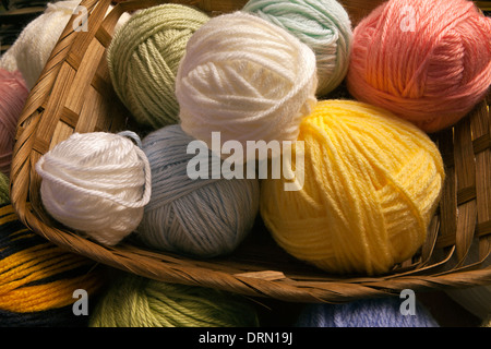 Multicolored yarn balls in a straw basket on a wooden table Stock Photo by  ©annakukhmar 40790863