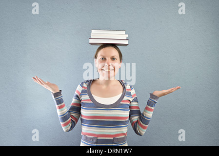 Smiling student with books on her head. Stock Photo