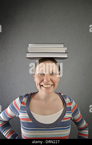 Smiling student with books on her head. Stock Photo