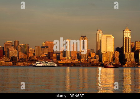 WASHINGTON - The cross-Sound ferry and the Seattle city skyline reflecting in Elliott Bay at sunset from West Seattle. 2013 Stock Photo