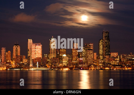 WASHINGTON - Moon peaking over the clouds of downtown Seattle and Elliott Bay from West Seattle. 2013 Stock Photo