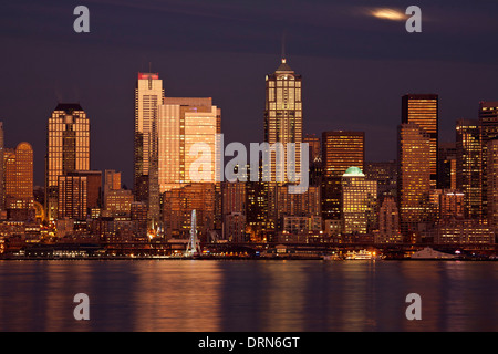 WASHINGTON - Moon peaking over the clouds of downtown Seattle and Elliott Bay from West Seattle. 2013 Stock Photo