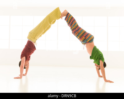 two men are doing yoga partners in a gym Stock Photo