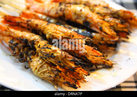 Plate of BBQ shrimp skewers on white plate Stock Photo