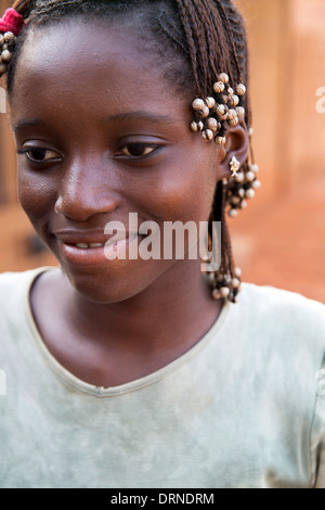 young girl standing outside her home in Bobo Dioulasso, Burkina Faso, Africa Stock Photo