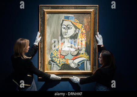 London, UK - 30 January 2014: staff members pose next to ‘Femme au costume turc dans un fanteuil, 1955' by Pablo Picasso (est £15-20 million) that will go on sale on the 4th February at Christie’s Credit:  Piero Cruciatti/Alamy Live News Stock Photo