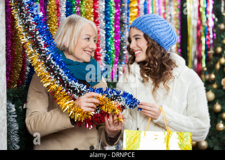 Mother And Daughter Shopping For Tinsels Stock Photo