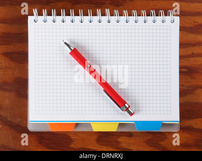 Open blank notebook with red pen on a table. Stock Photo