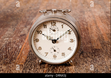 Vintage background with retro alarm clock on table Stock Photo