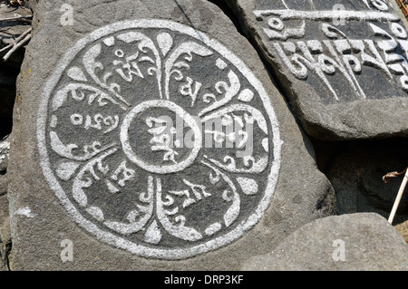 A mandala carved in stone in a mani wall in Nepal Stock Photo