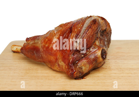 Roast leg of lamb on a wooden board against a white background Stock Photo