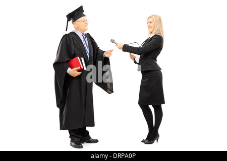 Full length portrait of young female interviewing mature man in graduation gown Stock Photo
