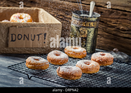 Icing sugar falling on fresh donuts Stock Photo