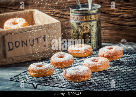 Icing sugar falling on fresh donuts Stock Photo