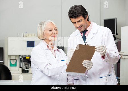 Scientists Writing On Clipboard In Laboratory Stock Photo