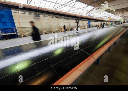 Duebendorf, Switzerland. , 29 Jan 2014: An engineer is passing by the solar cell covered elevator of 'Solar Impulse 2' (HB-SIB) aircraft that is set up in front of a wing part in the hangar in Duebendorf where the aircraft is built. Swiss aviation pioneer Bertrand Piccard wants to fly the solar powered aircraft around the world in 2015. Credit:  Erik Tham/Alamy Live News Stock Photo