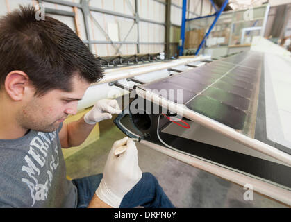 Duebendorf, Switzerland. , 29 Jan 2014: An engineer of the Solar Impulse project team is working on a stabilizer rudder of the solar powered aircraft 'Solar Impulse 2' (HB-SIB) that is built in a hangar in Duebendorf (Zurich), Switzerland. Swiss aviation pioneer Bertrand Piccard is planning to fly the futuristic solar powered aircraft around the world in 2015. Credit:  Erik Tham/Alamy Live News Stock Photo