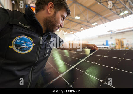 Duebendorf, Switzerland. , 29 Jan 2014: An engineer of the Solar Impulse project team is checking the surface of a solar cell-covered aileron of the experimental solar powered aircraft 'Solar Impulse 2' (HB-SIB) that is built in a hangar in Duebendorf (Zurich), Switzerland. Swiss aviation pioneer Bertrand Piccard is planning to fly the futuristic solar powered aircraft around the world in 2015. Credit:  Erik Tham/Alamy Live News Stock Photo
