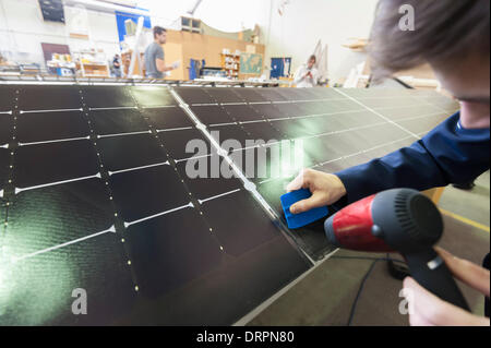 Duebendorf, Switzerland. , 29 Jan 2014: An engineer of the Solar Impulse project team is working on the surface of a solar cell-covered aileron of the aircraft 'Solar Impulse 2' (HB-SIB) that is built in Duebendorf (Zurich), Switzerland. Swiss aviation pioneer Bertrand Piccard is planning to fly the futuristic solar powered aircraft around the world in 2015. Credit:  Erik Tham/Alamy Live News Stock Photo