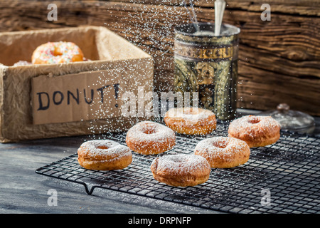 Falling icing sugar on fresh donuts Stock Photo