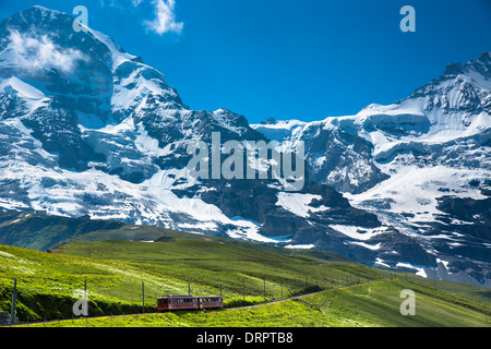 Jungfraubahn funicular train climbs to the Jungfrau from Kleine Scheidegg in the Swiss Alps in Bernese Oberland, Switzerland Stock Photo