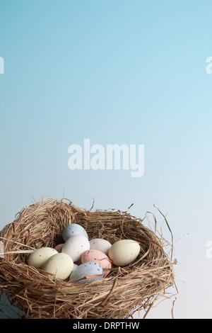 Nest of hay with pastel colored easter eggs Stock Photo
