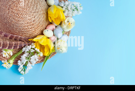 Straw hat decorated for easter with flowers, chicks and easter eggs Stock Photo