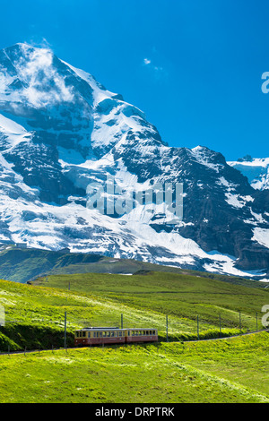 Jungfraubahn funicular train climbs to the Jungfrau from Kleine Scheidegg in the Swiss Alps in Bernese Oberland, Switzerland Stock Photo