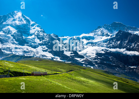 Jungfraubahn funicular train climbs to the Jungfrau from Kleine Scheidegg in the Swiss Alps in Bernese Oberland, Switzerland Stock Photo