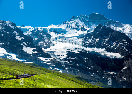 Jungfraubahn funicular train climbs to the Jungfrau from Kleine Scheidegg in the Swiss Alps in Bernese Oberland, Switzerland Stock Photo