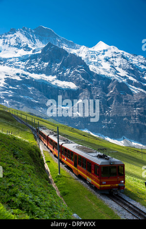 Jungfraubahn funicular train climbs to the Jungfrau from Kleine Scheidegg in the Swiss Alps in Bernese Oberland, Switzerland Stock Photo