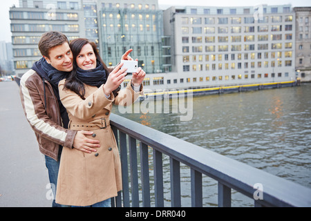 Tourists couple taking pictures in city with a smartphones Stock Photo