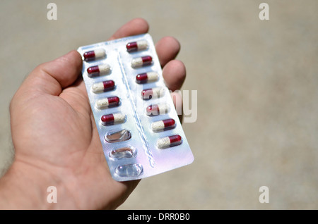 sheet of pills in hand, drugs, pharmaceutical, addiction Stock Photo