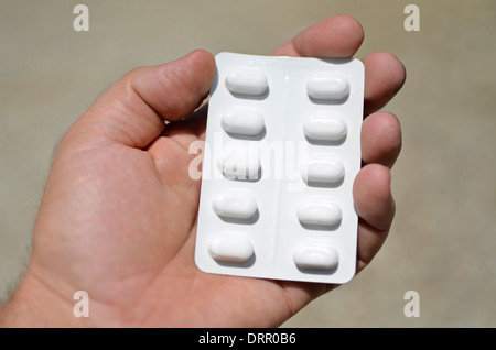 sheet of pills in hand, pharmaceutical, addiction Stock Photo