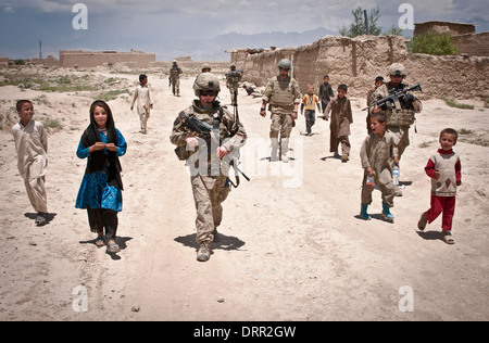 Afghan children walk alongside US Airmen with the 455th Air Expeditionary Wing as they patrol a village near Bagram Airfield June 6, 2012 in Parwan province, Afghanistan. Stock Photo