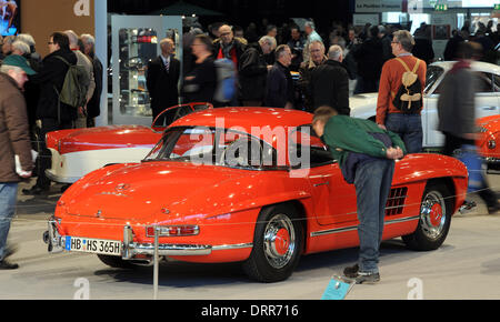 Bremen, Germany. 31st Jan, 2014. Visitors look at a Mercedes-Benz 300 SL Cabrio with Hardtop from 1962 at the Bremen Classic Motorshow trade fair in Bremen, Germany, 31 January 2014. The focal points of this year's classic car show is the 'economic miracle'. The fair runs until 02 February. Photo: INGO WAGNER/dpa/Alamy Live News Stock Photo