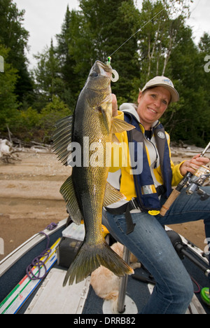 Woman angler holding the summer walleye she caught in Northern Ontario, Canada. Stock Photo