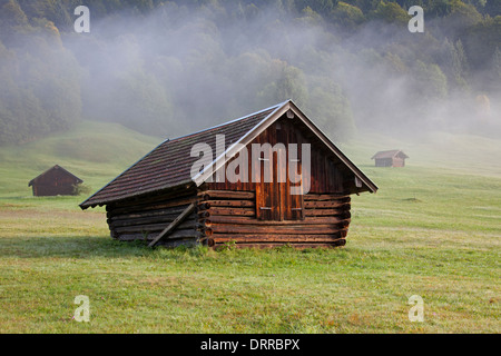 Wooden huts / granaries in the mist along lake Gerold / Geroldsee near Mittenwald, Upper Bavaria, Germany Stock Photo
