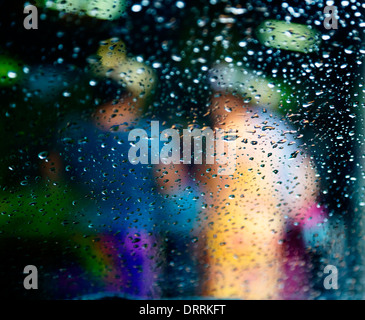 Viewed through wet glass. Two women dressed in traditional dresses and headdress in Rarotonga, Cook Islands, South Pacific. Stock Photo