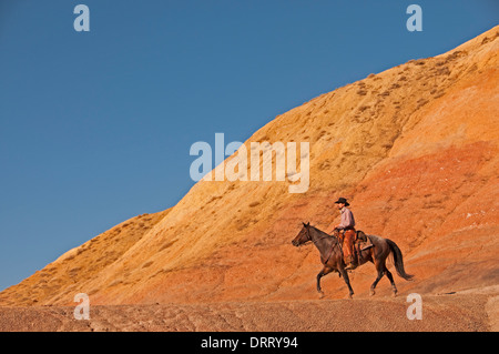 Cowboy rides his horse in the Painted Hills area of the Bighorn Mountains of Wyoming Stock Photo