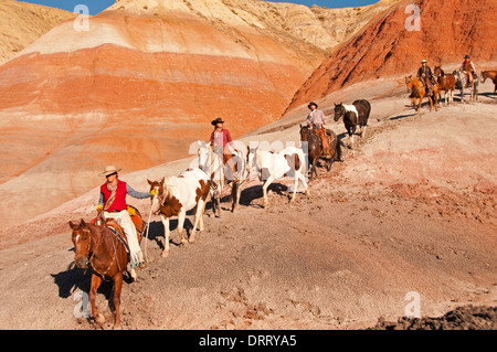 Cowboys and cowgirls -- wranglers -- lead horses in the Painted Hills area of the Bighorn Mountains of Wyoming Stock Photo