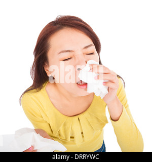young woman with a an allergy sneezing into tissues Stock Photo