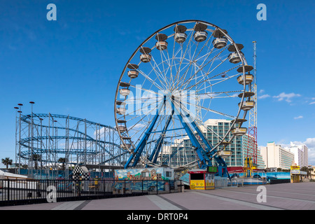 Ferris wheel and roller coaster beyond in the Daytona Beach boardwalk amusement park. Stock Photo