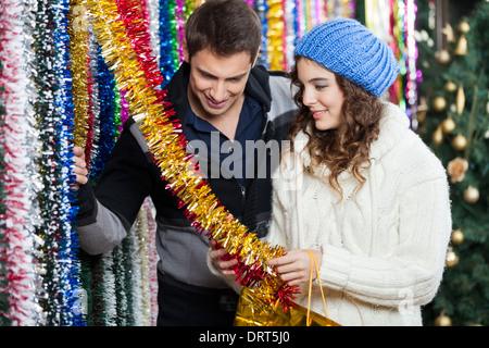 Couple Shopping For Tinsels At Store Stock Photo