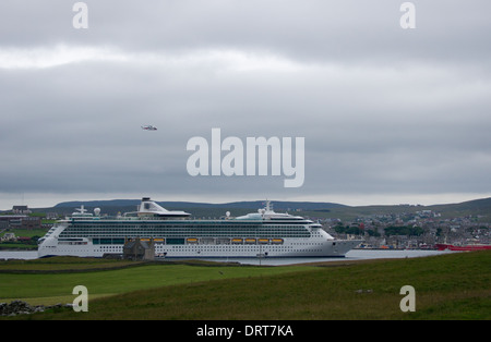 The Brilliance Of The Seas cruise ship moored in Bressay sound with the town of Lerwick, Shetland, in the back ground. Stock Photo